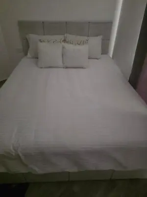 a bed with white sheets and pillows in a room at 2 Bedroom Duplex - Hurghada in Hurghada
