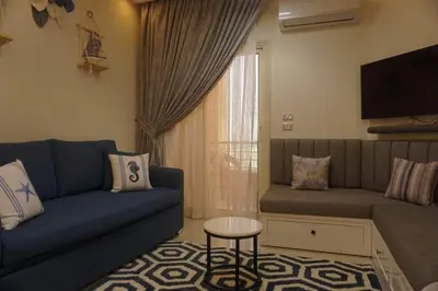 a living room with a blue couch and a tv at Seaview Classy 2Bedroom Suite with beach access in Hurghada