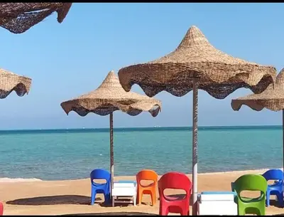 a group of chairs and umbrellas on a beach at Seaview Classy 2Bedroom Suite with beach access in Hurghada