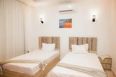 two beds in a room with white walls at 4,5 Zimmer Kiteapartment Selena Bay in Hurghada