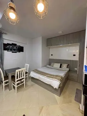 a bedroom with a bed and a table and chairs at Sunrise Luxury Apartment in Hurghada