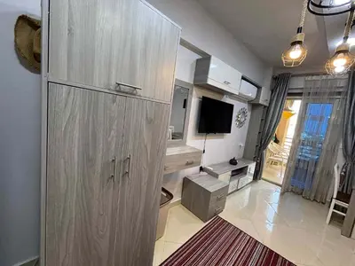 a large wooden cabinet in a room with a television at Sunrise Luxury Apartment in Hurghada