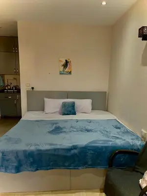 a bedroom with a large bed with a blue blanket at Studio Mirage Bay in Hurghada