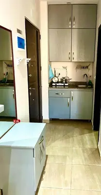 a large kitchen with blue cabinets and a counter top at Studio Mirage Bay in Hurghada