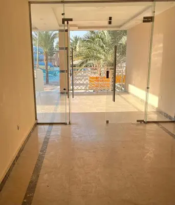 an open glass door with a view of a pool at Studio Mirage Bay in Hurghada