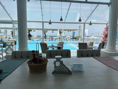 a restaurant with a pool and a table and chairs at Selena Bay Resort - VIP apartment with Private Beach Area in Hurghada