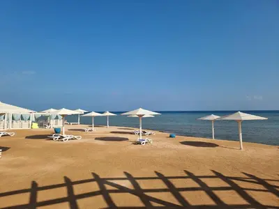 a group of umbrellas and chairs on a beach at Selena Bay Resort - VIP apartment with Private Beach Area in Hurghada