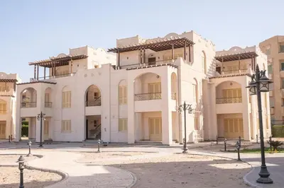 a large white building with a courtyard in front of it at Fayrouz Compound in Hurghada
