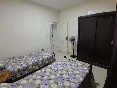 a bedroom with a bed and a dresser at Fayrouz Compound in Hurghada