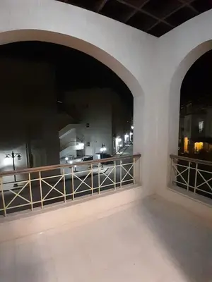a balcony with a view of a city at night at Fayrouz Compound in Hurghada