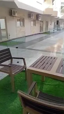 a empty room with a bench and green grass at La bella resort touristic walkway hurghada in Hurghada