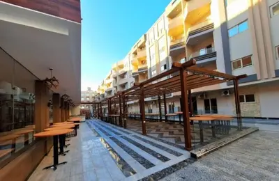 a row of tables and benches in a building at La bella resort touristic walkway hurghada in Hurghada