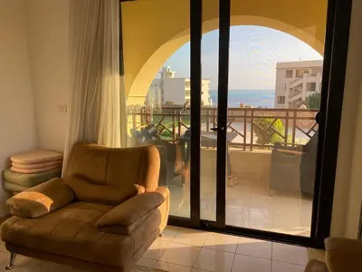 a living room with a chair and a balcony at Sea View luxury chalet in Hurghada