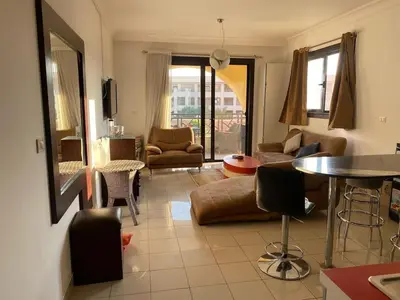 a living room with a couch and a table and chairs at Sea View luxury chalet in Hurghada