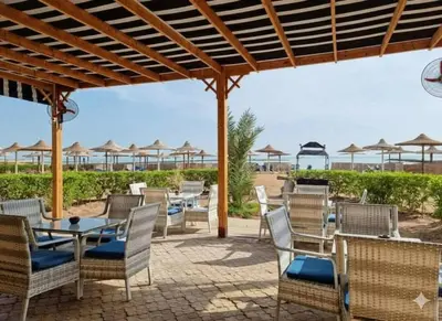 a patio with chairs and tables and umbrellas at Tartils Beach Resort Al-Ahyaa in Hurghada