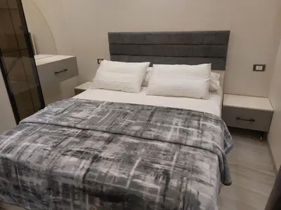 a bedroom with a bed with a gray and white comforter at Solitaire in Hurghada