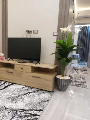 a living room with a television on a wooden entertainment center at Solitaire in Hurghada