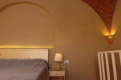 a bedroom with a bed and a lamp on a wall at Mountian View Domes in Al Aqālitah