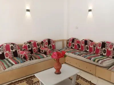 a living room with couches and a vase on a table at Bait el gabal in Al Aqālitah