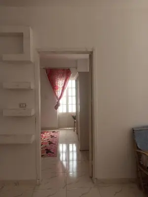 an empty room with a window and a stair case at Bait el gabal in Al Aqālitah