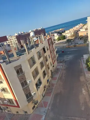 an empty street next to a building with the ocean at solitaire in Hurghada
