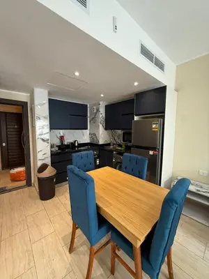 a kitchen with a wooden table and blue chairs at Casa Bonita 2307 in Hurghada