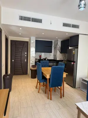 a kitchen and dining room with a table and blue chairs at Casa Bonita 2307 in Hurghada