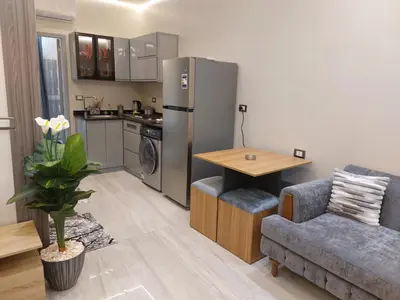 a kitchen with a refrigerator and a table and a couch at سولتير in Hurghada