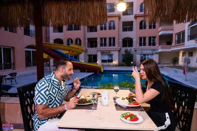 a man and woman sitting at a table eating food at Contenintal Rosa Boho Aquapark Hotel 3 Stars in Hurghada