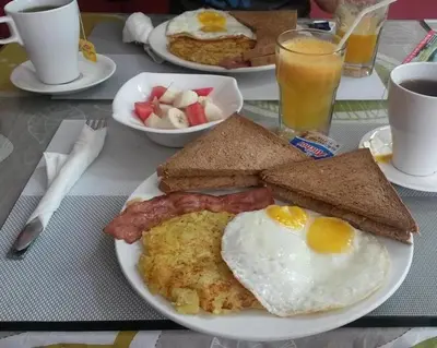 a plate of breakfast food with eggs bacon and toast at Contenintal Rosa Boho Aquapark Hotel 3 Stars in Hurghada