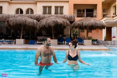 a man and a woman standing in a swimming pool at Contenintal Rosa Boho Aquapark Hotel 3 Stars in Hurghada