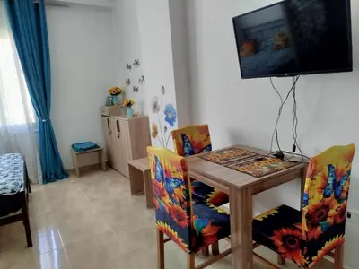 a dining room with a table and chairs and a television at Sheraton Plaza 319 in Hurghada