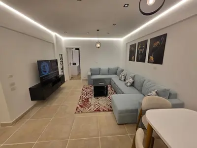 a living room with a couch and a tv at Cozy Fully Furnished Apartment in Hurghada