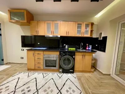 a kitchen with wooden cabinets and a dishwasher at مارينا الغردقه in Hurghada