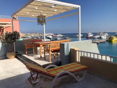 a patio with a table and chairs and a view of a marina at مارينا الغردقه in Hurghada