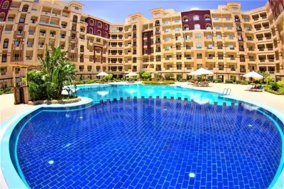 a large swimming pool in front of a large building at For Rent Florenza Khamsin Residential Apartment in Hurghada