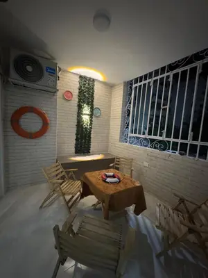 a room with a table and chairs and a window at شقه لك ب الكامل فندقي in Safaga