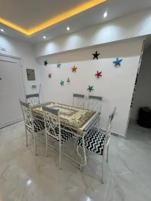a dining room table and chairs with stars on the wall at شقه لك ب الكامل فندقي in Safaga