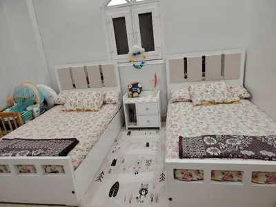 a bedroom with two beds and a window at venti house1 in Nag` el-Ramla
