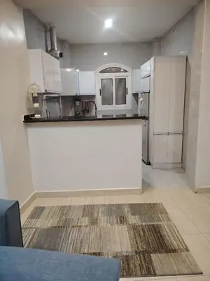 a kitchen with white cabinets and a counter top at venti house1 in Nag` el-Ramla