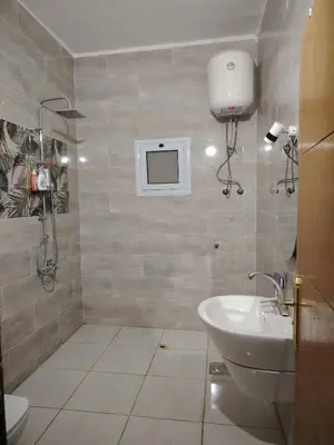 a bathroom with a sink and a tv on the wall at venti house1 in Nag` el-Ramla