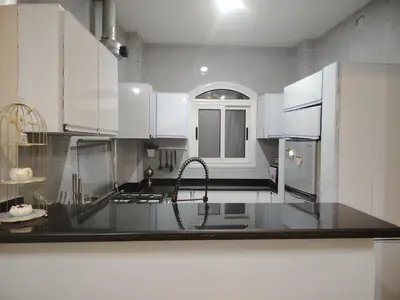 a kitchen with white cabinets and a sink at venti house1 in Nag` el-Ramla