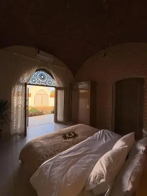 a large bed in a room with a window at Temple Of The Golden Sun in Luxor