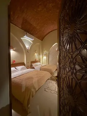 a bedroom with two beds in a room with a ceiling at Temple Of The Golden Sun in Luxor
