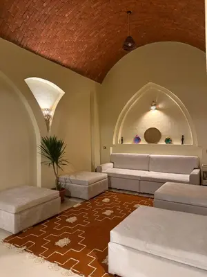 a living room with white couches and a table at Temple Of The Golden Sun in Luxor
