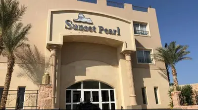 a suntrust park building with palm trees in front of it at Sunset Barrel in Hurghada