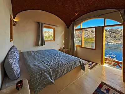a bedroom with a bed and a large window at ASSINGAR Island in Aswan
