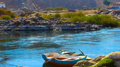 two boats sitting in the water on a river at ASSINGAR Island in Aswan