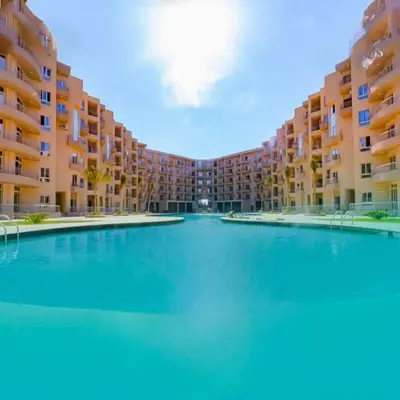 a large swimming pool in front of a large apartment building at البرنسيسة in Hurghada