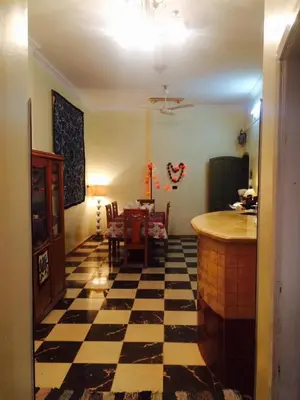 a living room with a checkered floor and a kitchen at Sphinx in Al Karnak